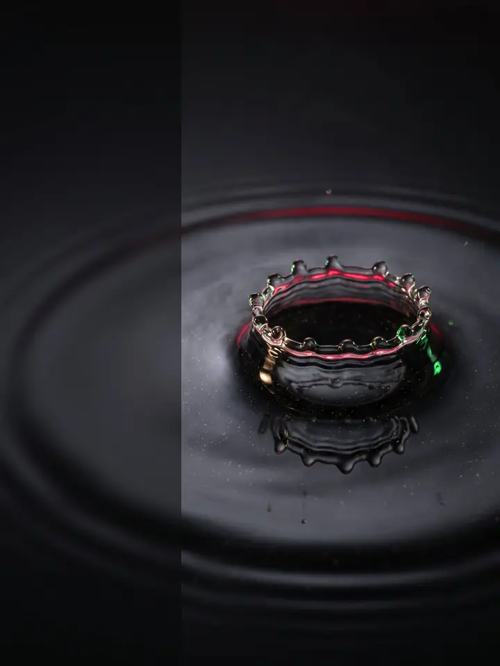 A near-black macro liquid crown suspends crimson, champagne-gold, and leaf-green particles as an intriguing first-scroll SCT wellness hero without anatomy, people, or claims.